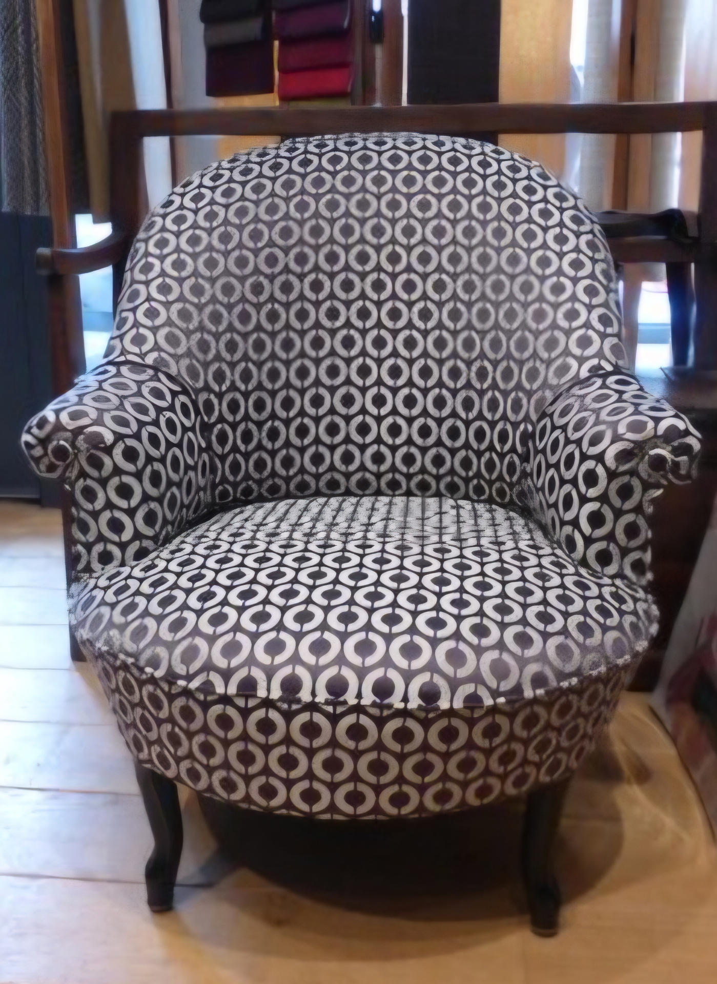 Fauteuil tonneau garni d'un tissu à motifs cercles noir et blanc