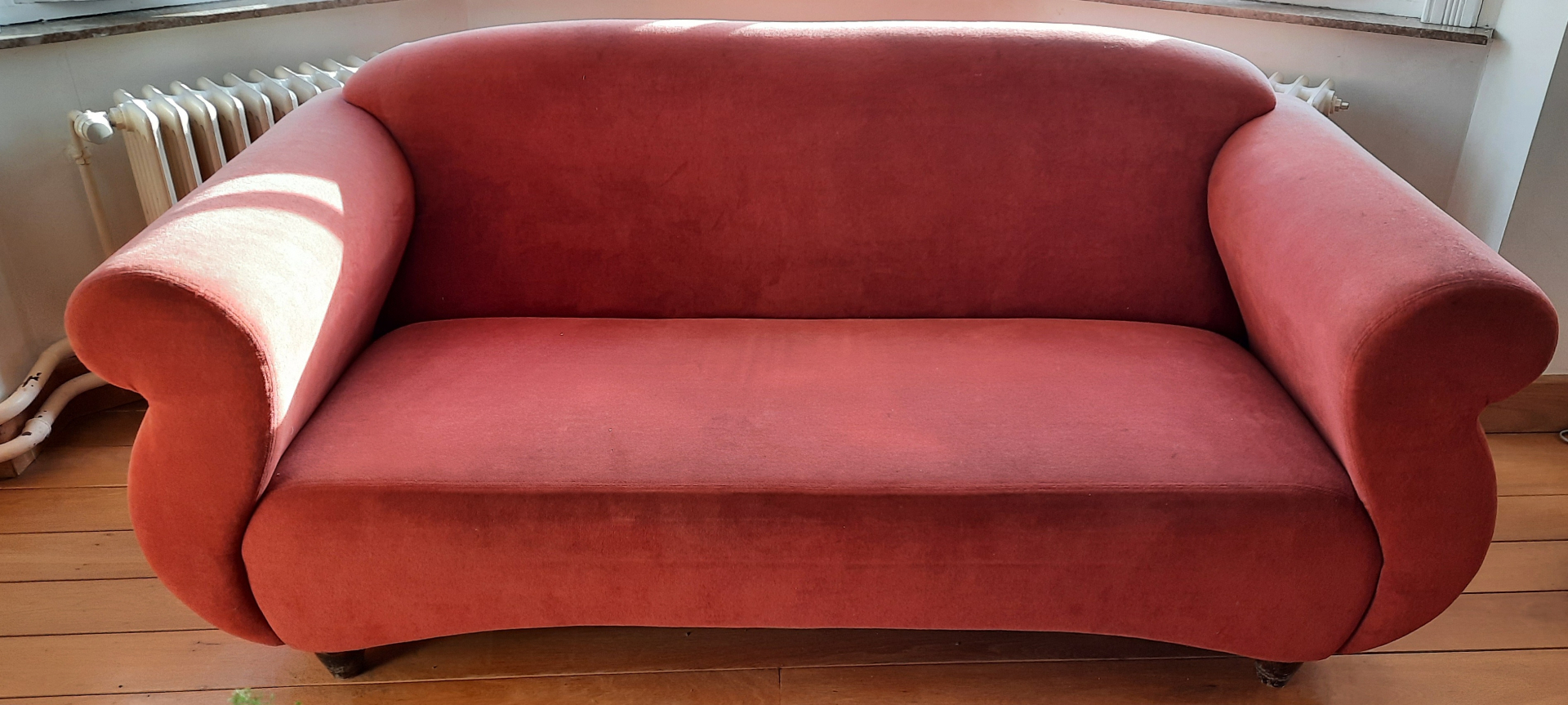 Canapé ancien à dossier galbé garni en velours rouge brique
