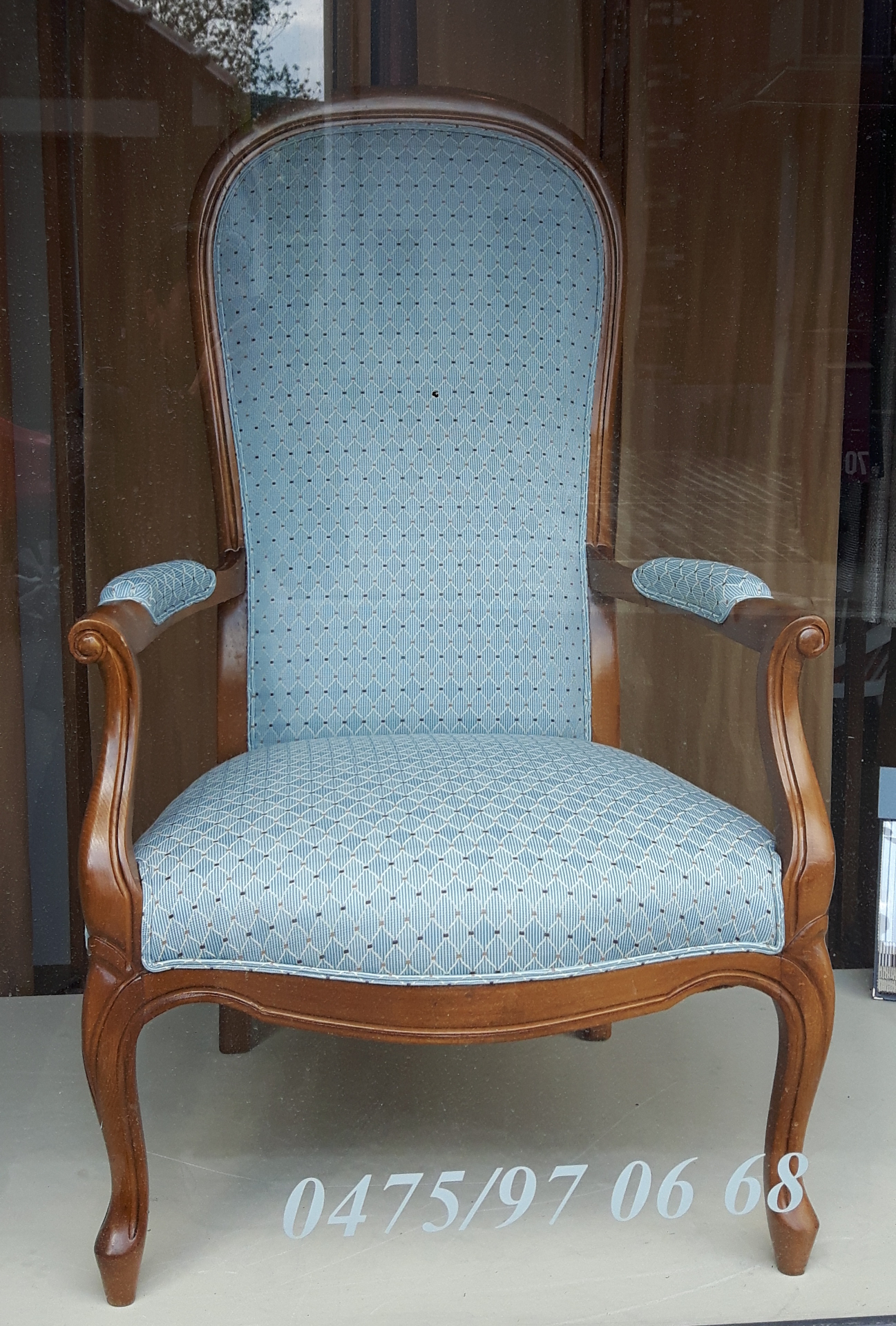 Fauteuil Voltaire garni en tissu bleu ciel à motifs losanges
