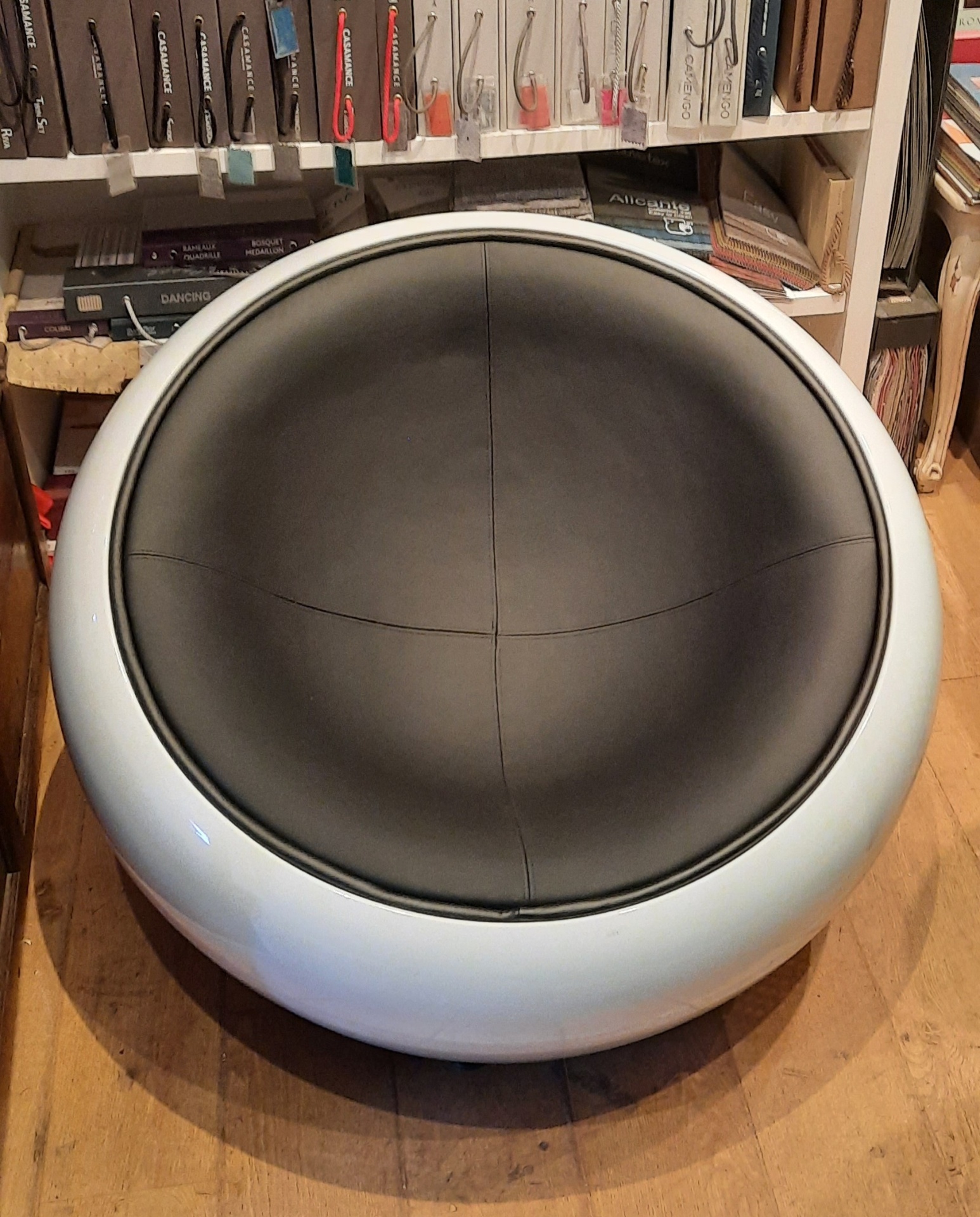 Fauteuil boule design garni en simili cuir gris anthracite, coque blanche laquée