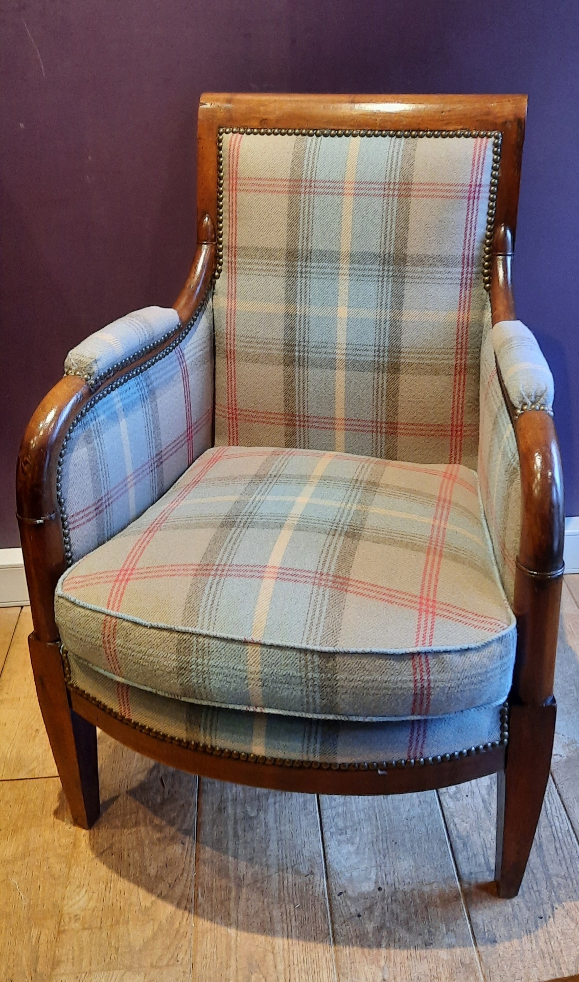 Bergère Empire en acajou garnie en lainage écossais vert et rouge, clouté laiton