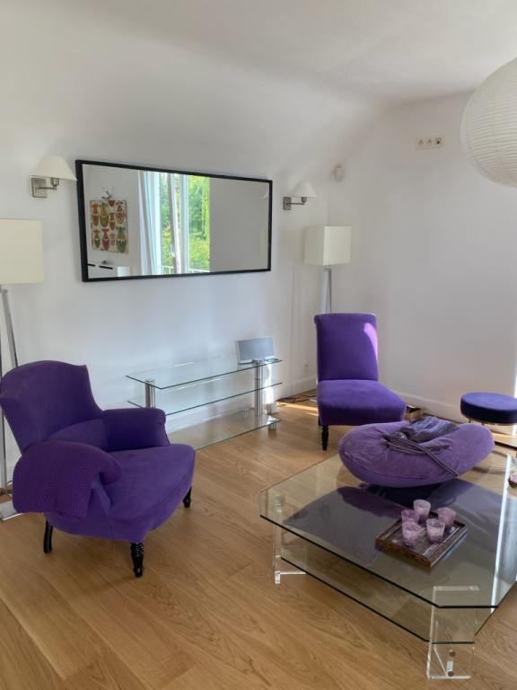 Salon — paire de fauteuils crapauds et pouf garnis en velours violet