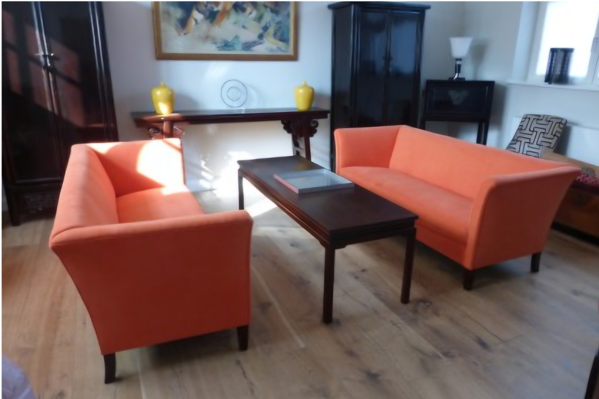 Salon contemporain — paire de canapés garnis en velours orange, pieds bois foncé