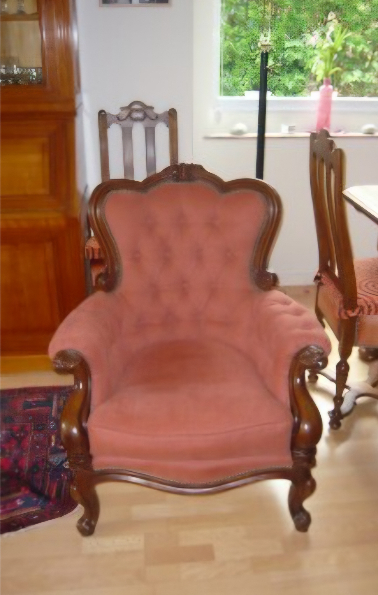 Fauteuil crapaud capitonné garni en velours rose corail, bois acajou sculpté