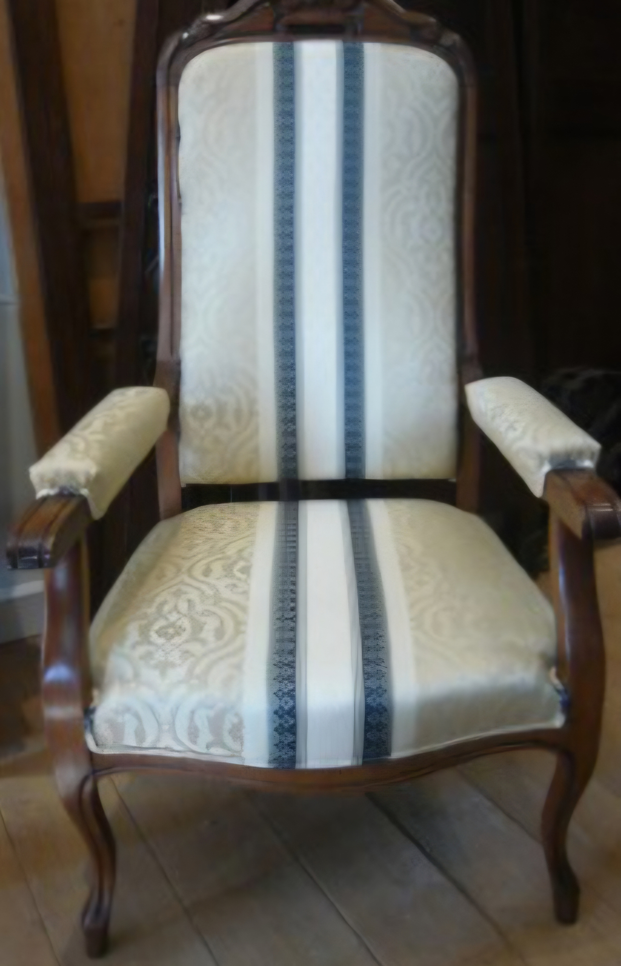 Fauteuil ancien en bois garni d'un tissu clair à bandes verticales bleues