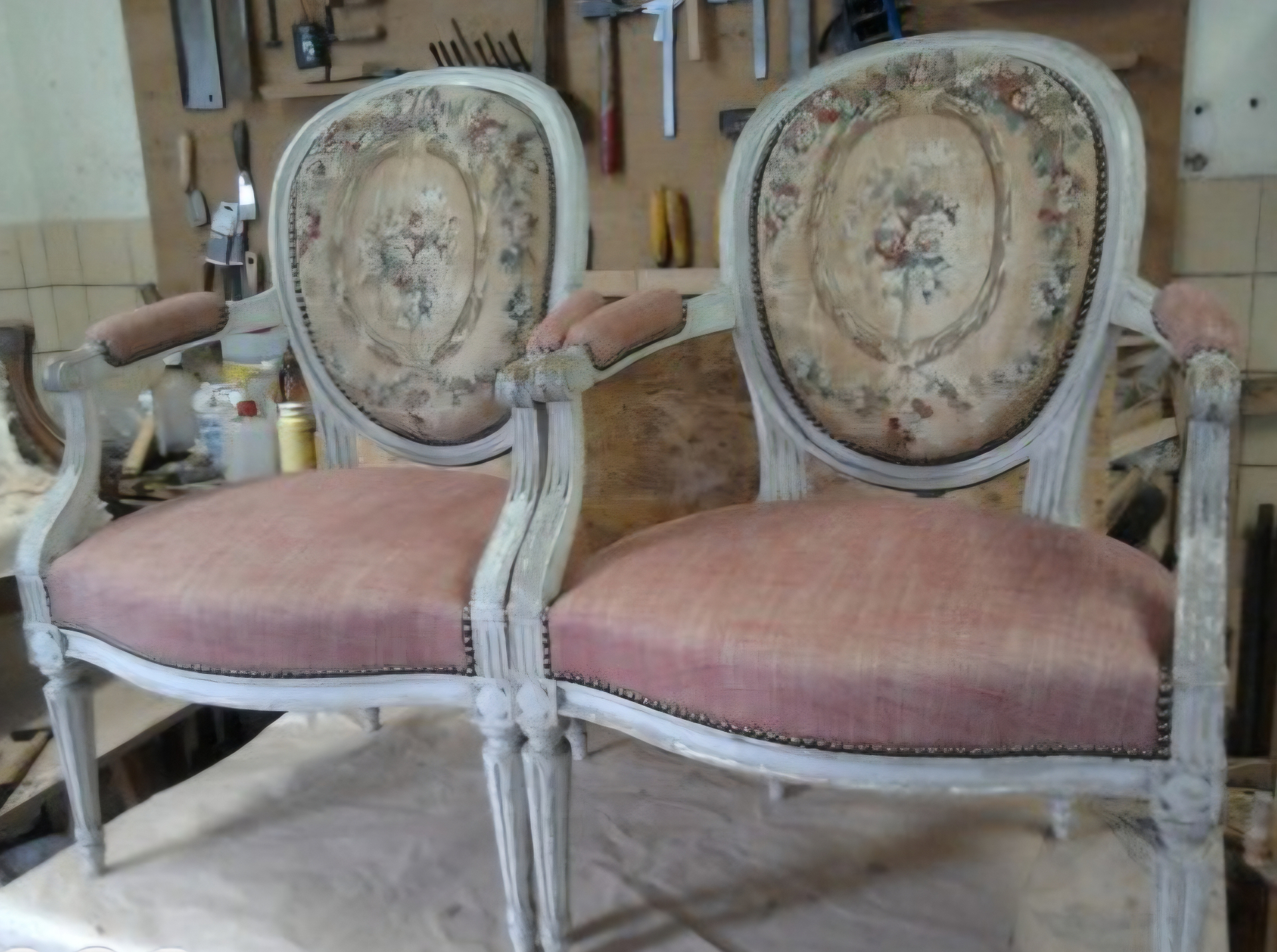 Paire de fauteuils Louis XVI en cours de restauration avec garnissage rose et dossiers à motifs floraux