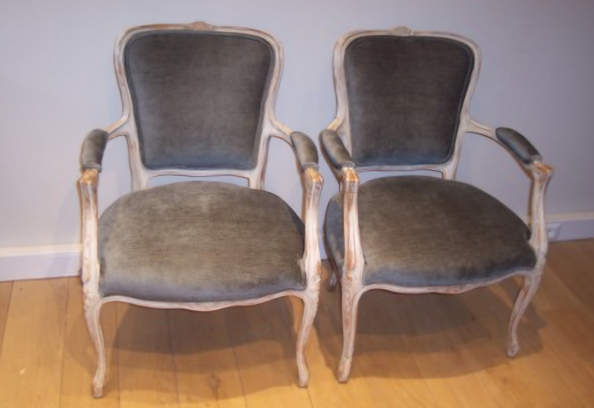 Paire de fauteuils cabriolet patinés blanc garnis en velours gris