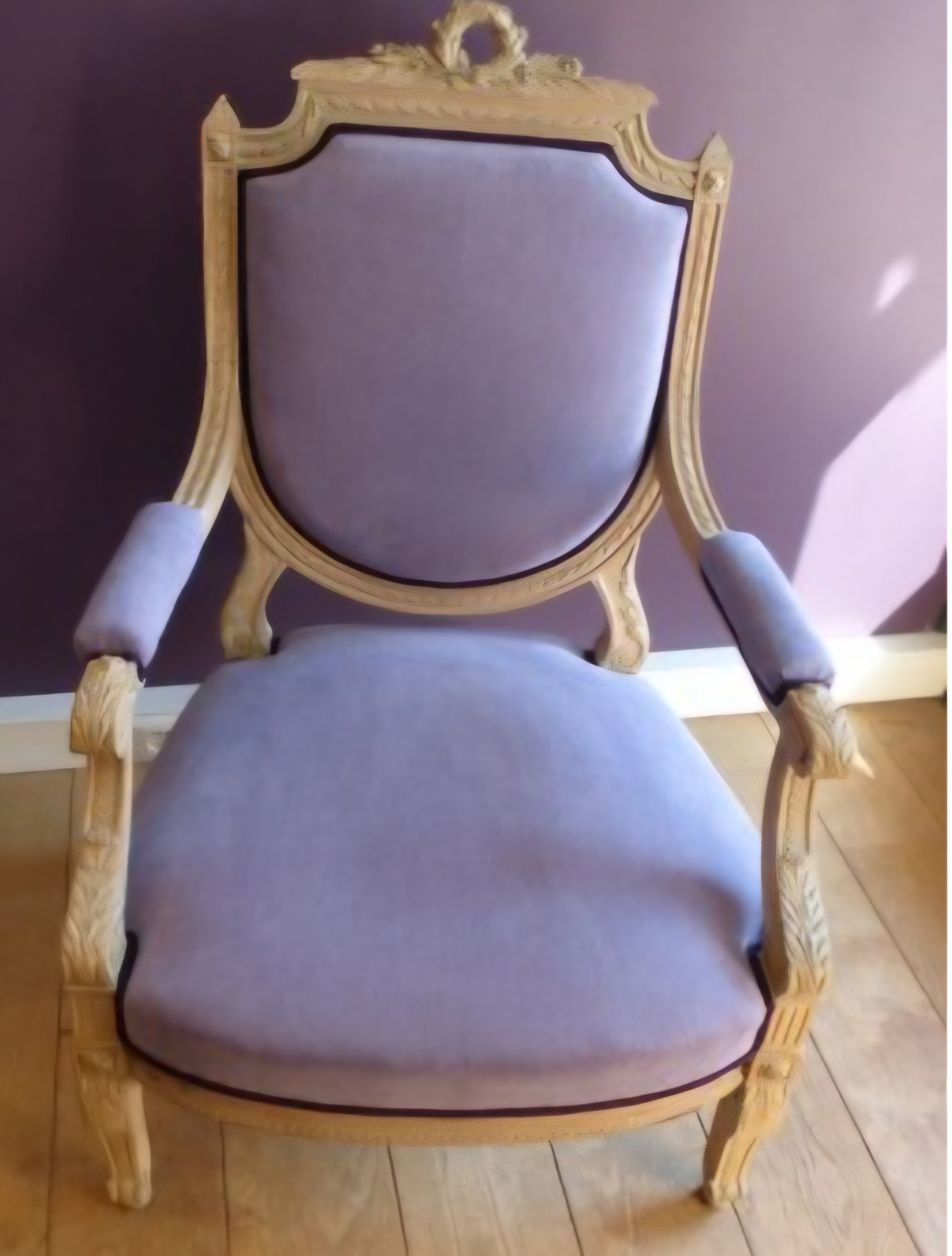 Fauteuil Louis XVI en bois sculpté patiné garni en tissu mauve avec passepoil contrasté