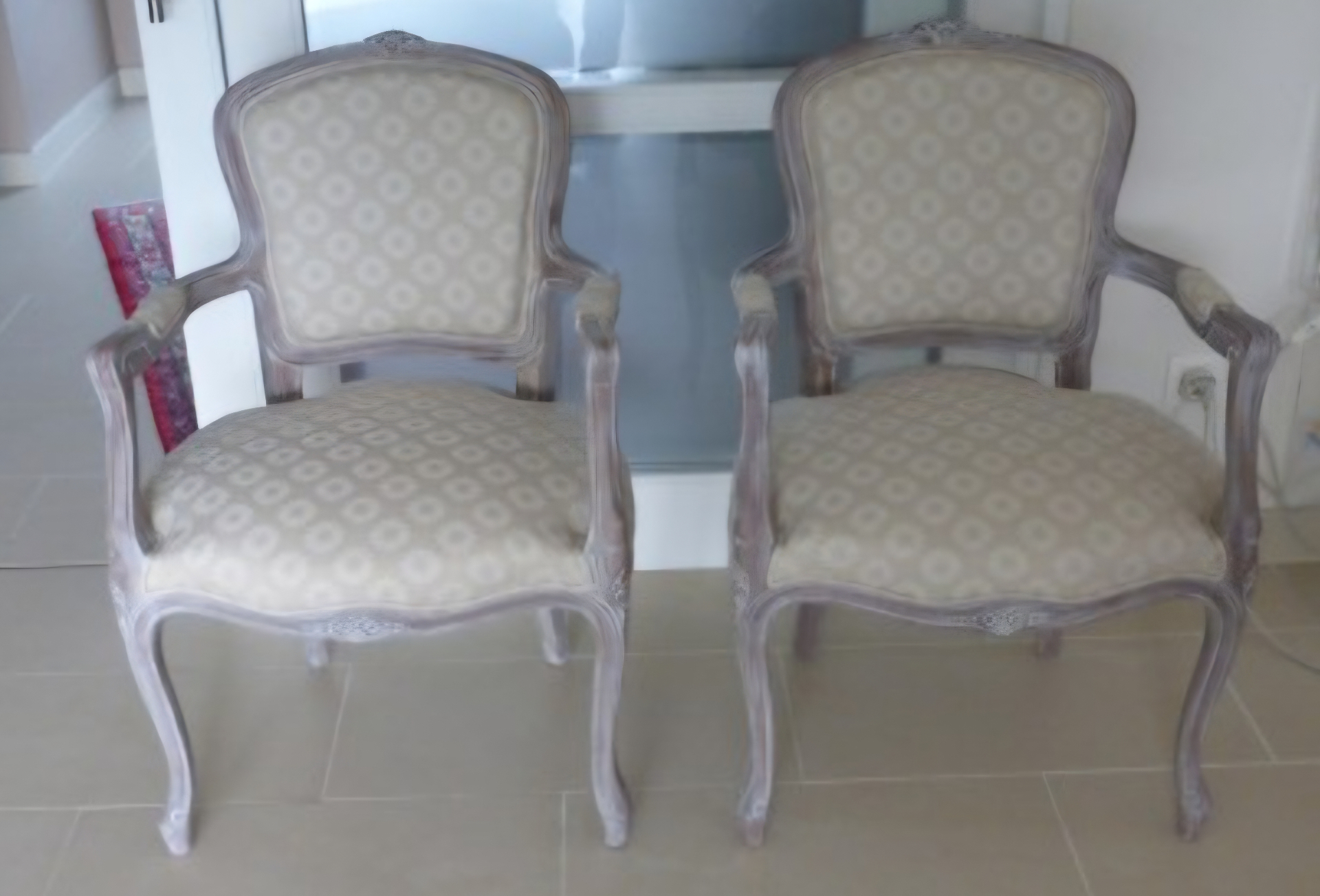 Paire de fauteuils cabriolet patinés garnis en tissu beige à motifs géométriques